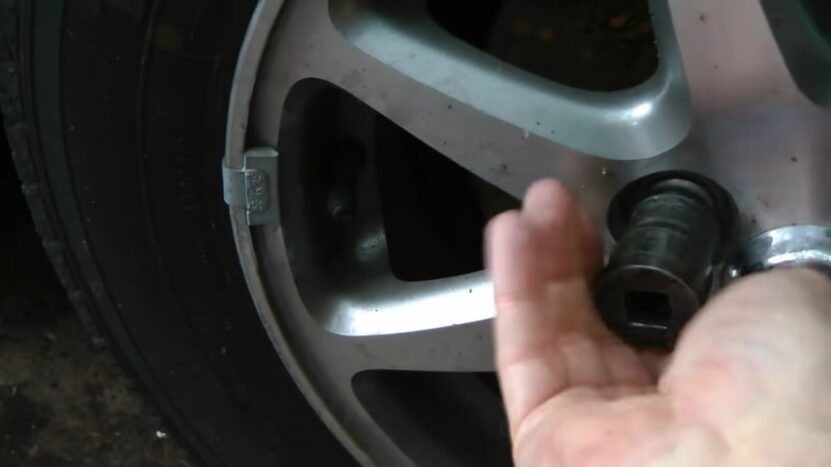 Remove the lug nuts and tire